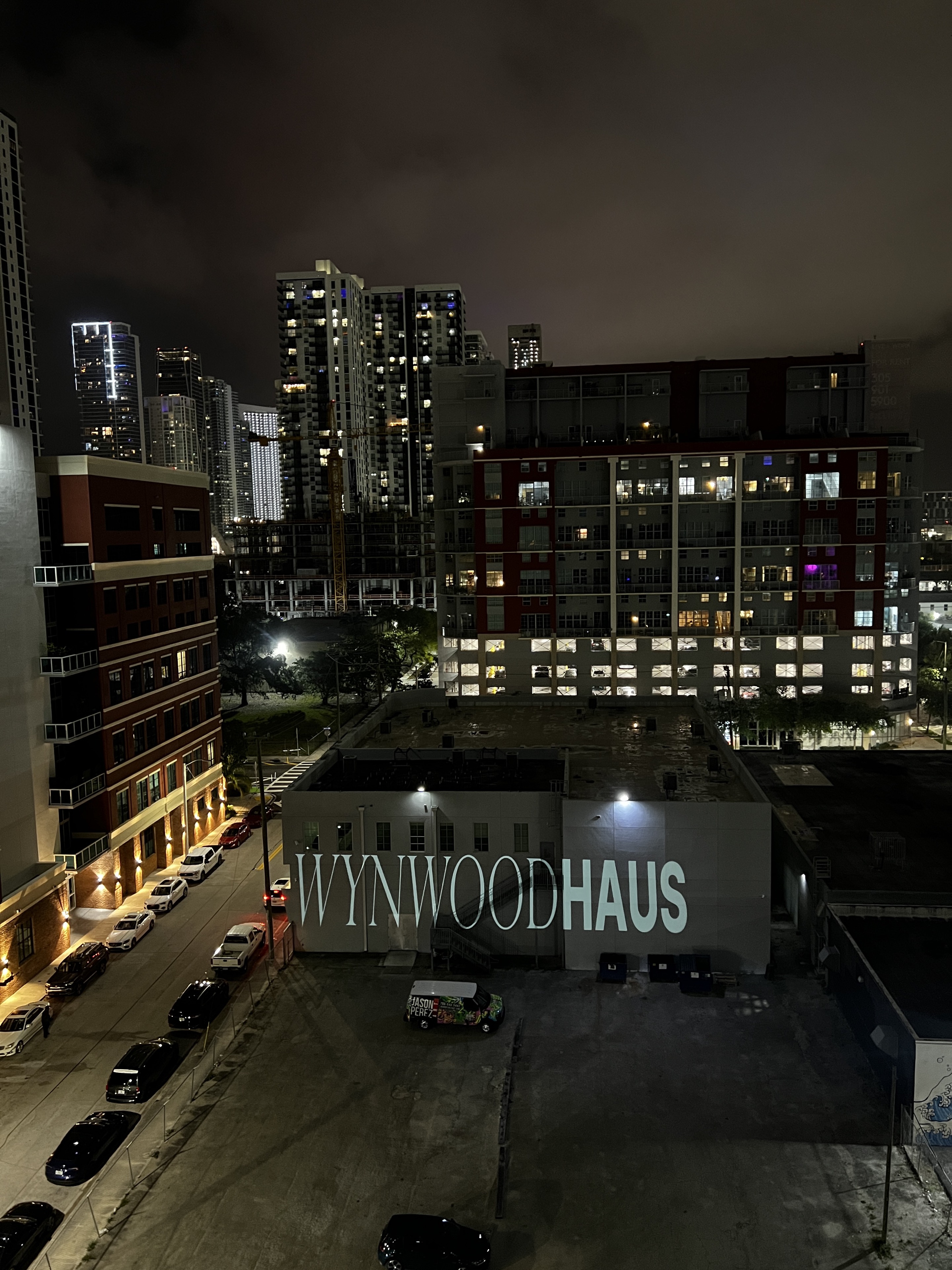 Wynwood Haus branding projected across a building in the city at night