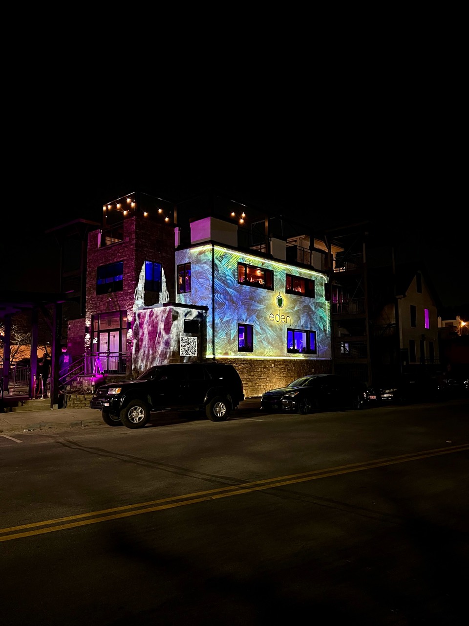 Eden branding projected across a building at night